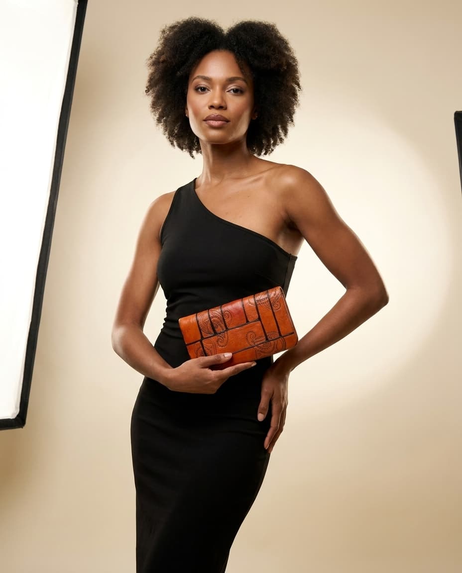 Model holding the orange paisley clutch