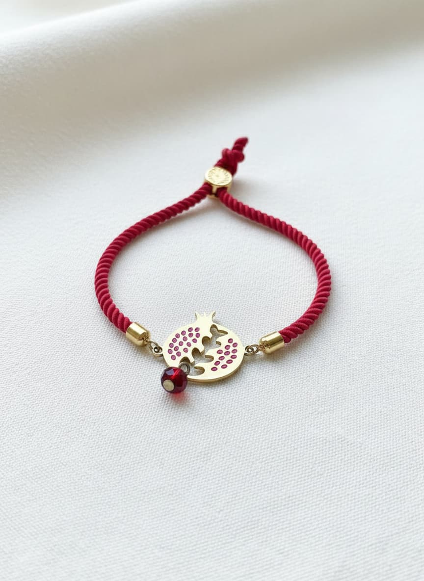 Gold-plated red pomegranate bracelet on white