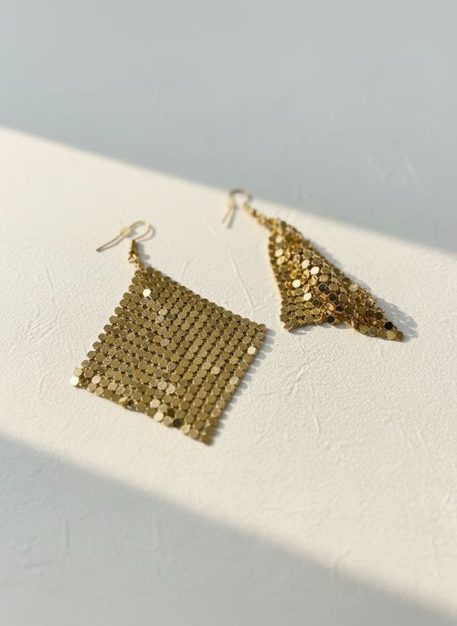 Gold sequin diamond-shape earrings on white