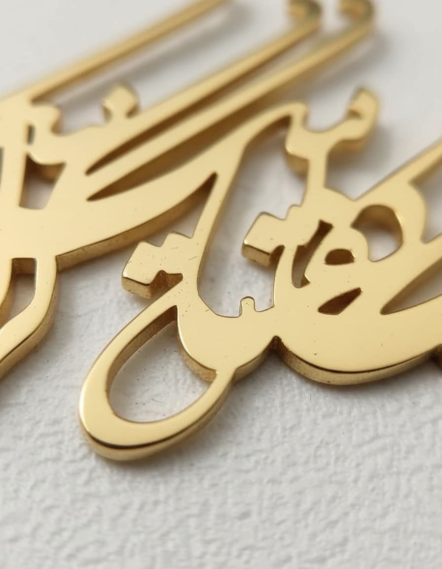 Gold-plated Persian calligraphy pendant necklace with red bead on white background
