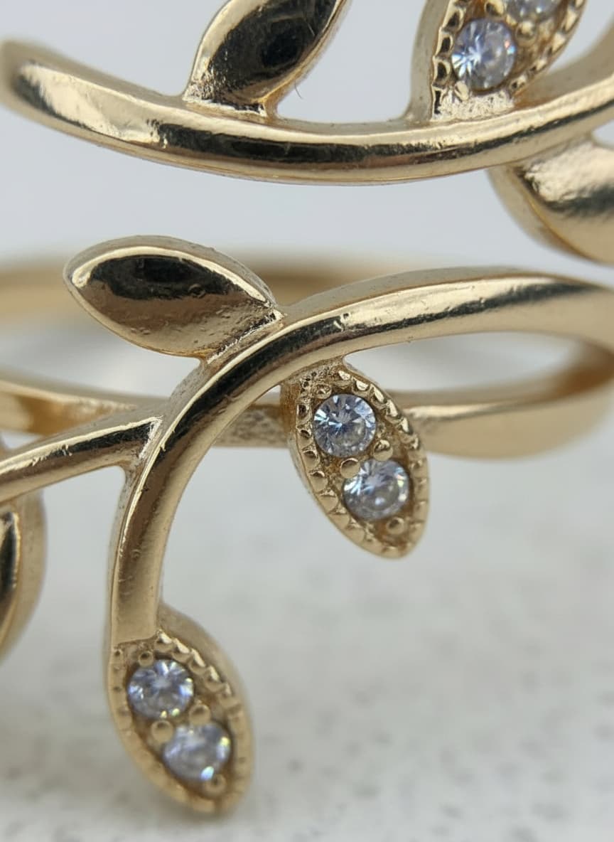 Macro close-up of the gold leaf vine ring's crystal leaves