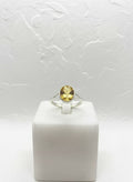 Silver-tone honey-yellow oval stone ring on white background