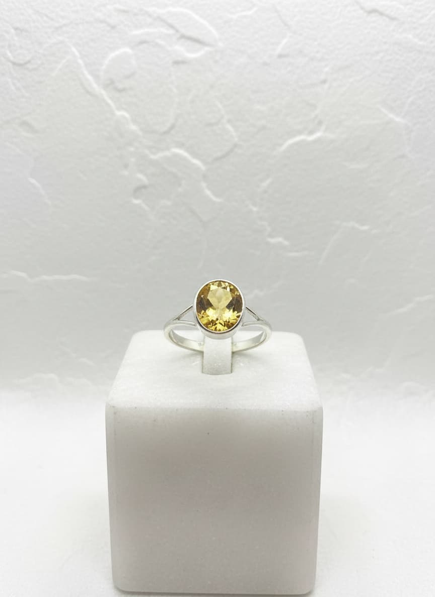 Silver-tone honey-yellow oval stone ring on white background