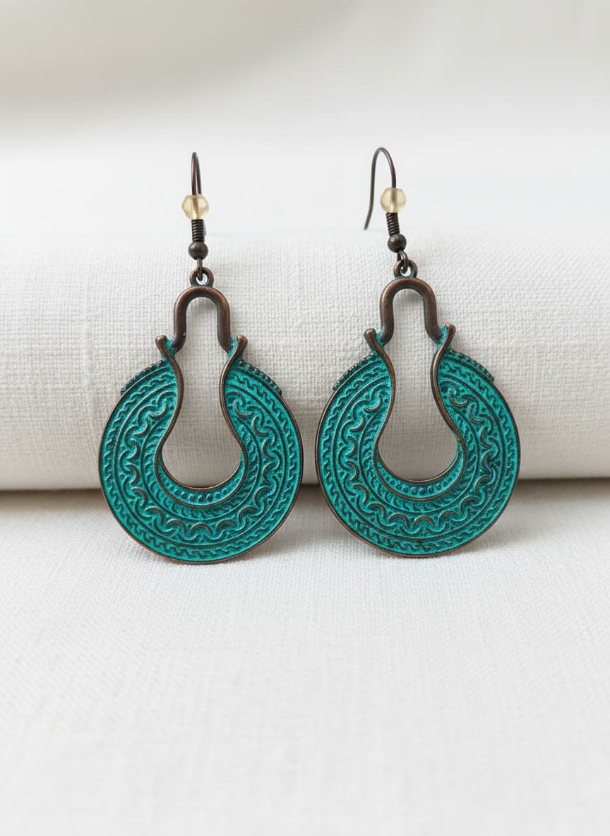 Copper-plated turquoise crescent engraved earrings on white