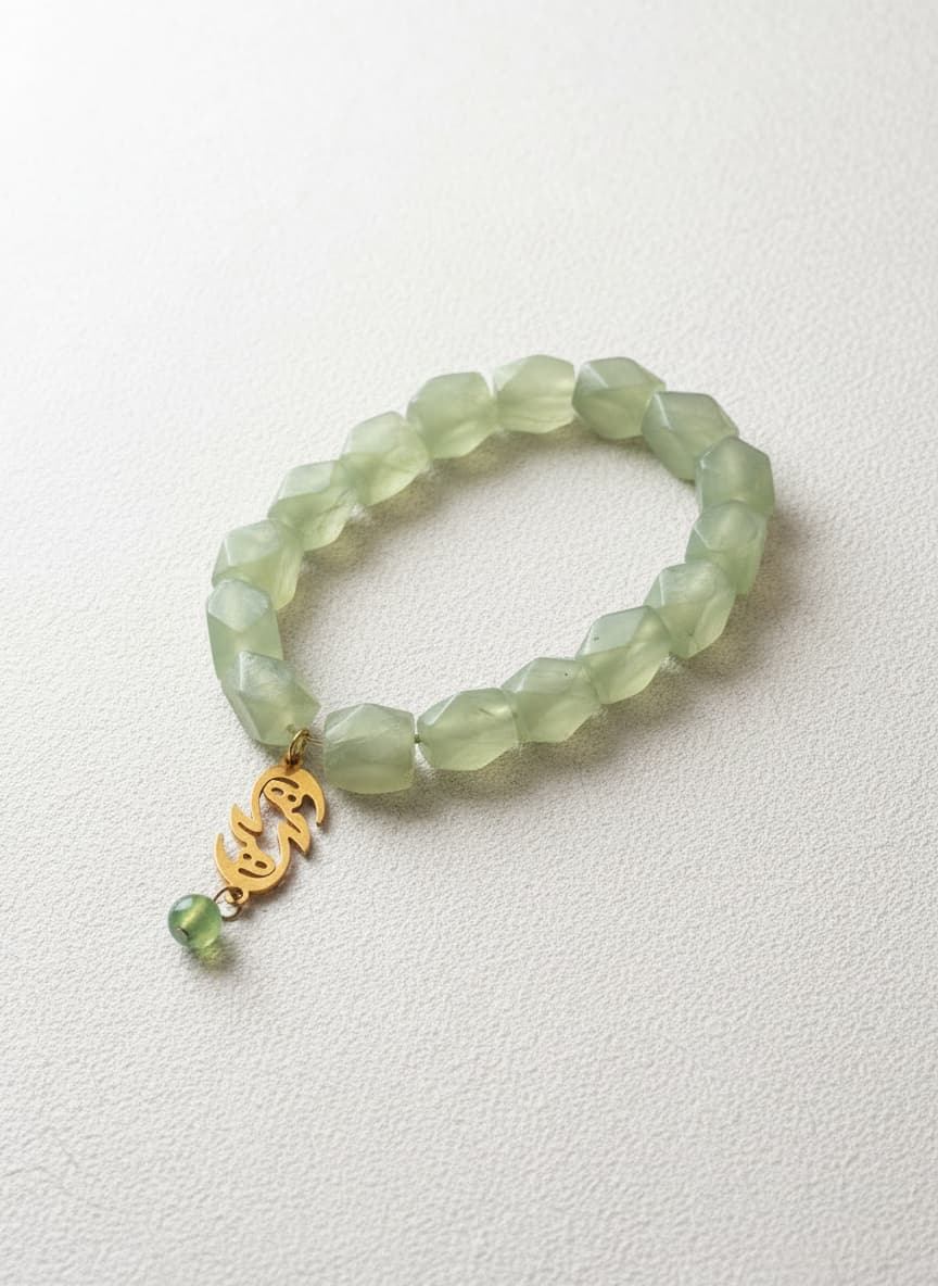 Green jade bracelet with gold eshgh charm on white