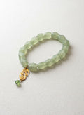 Green jade bracelet with gold eshgh charm on white
