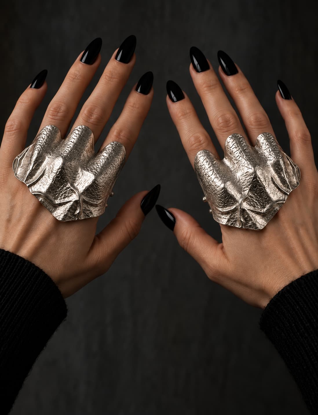 Silver-tone hammered statement ring worn on both hands