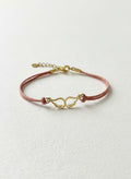 Gold angel wings bracelet on brown leather cord