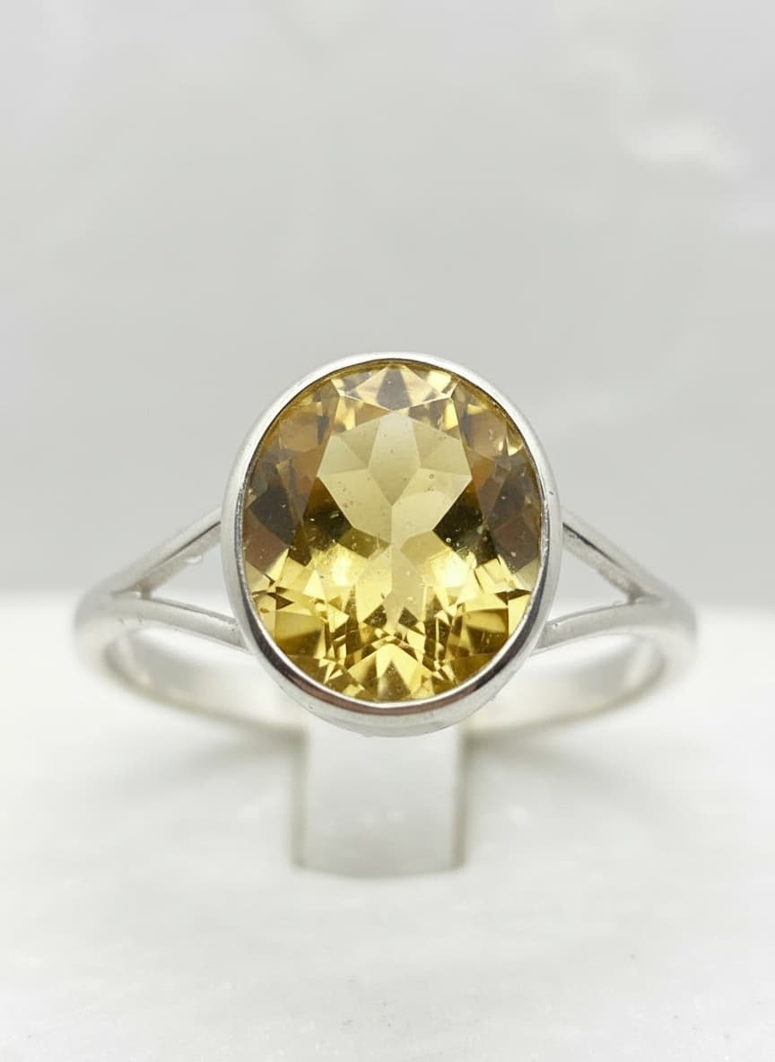 Honey-yellow oval stone ring on a white pedestal