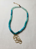 Gold calligraphy necklace with green-blue stone beads