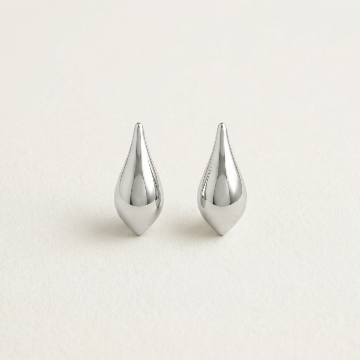 Silver teardrop hanging earrings on white