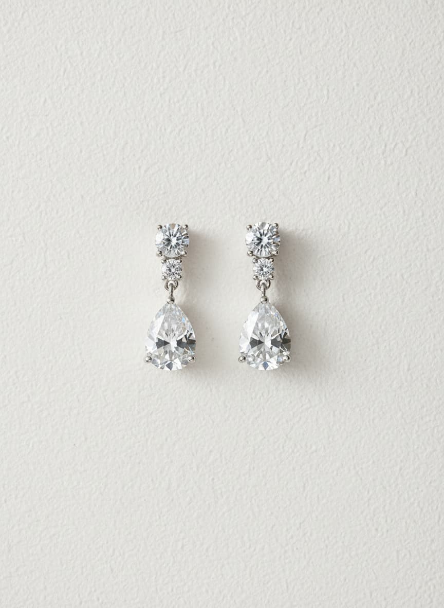 Silver-tone pear drop crystal earrings on white background