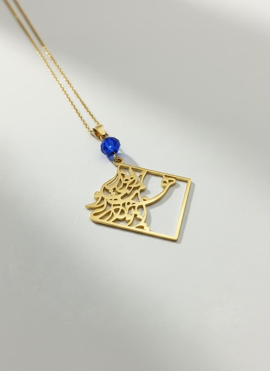 Gold calligraphy necklace with blue stone on white