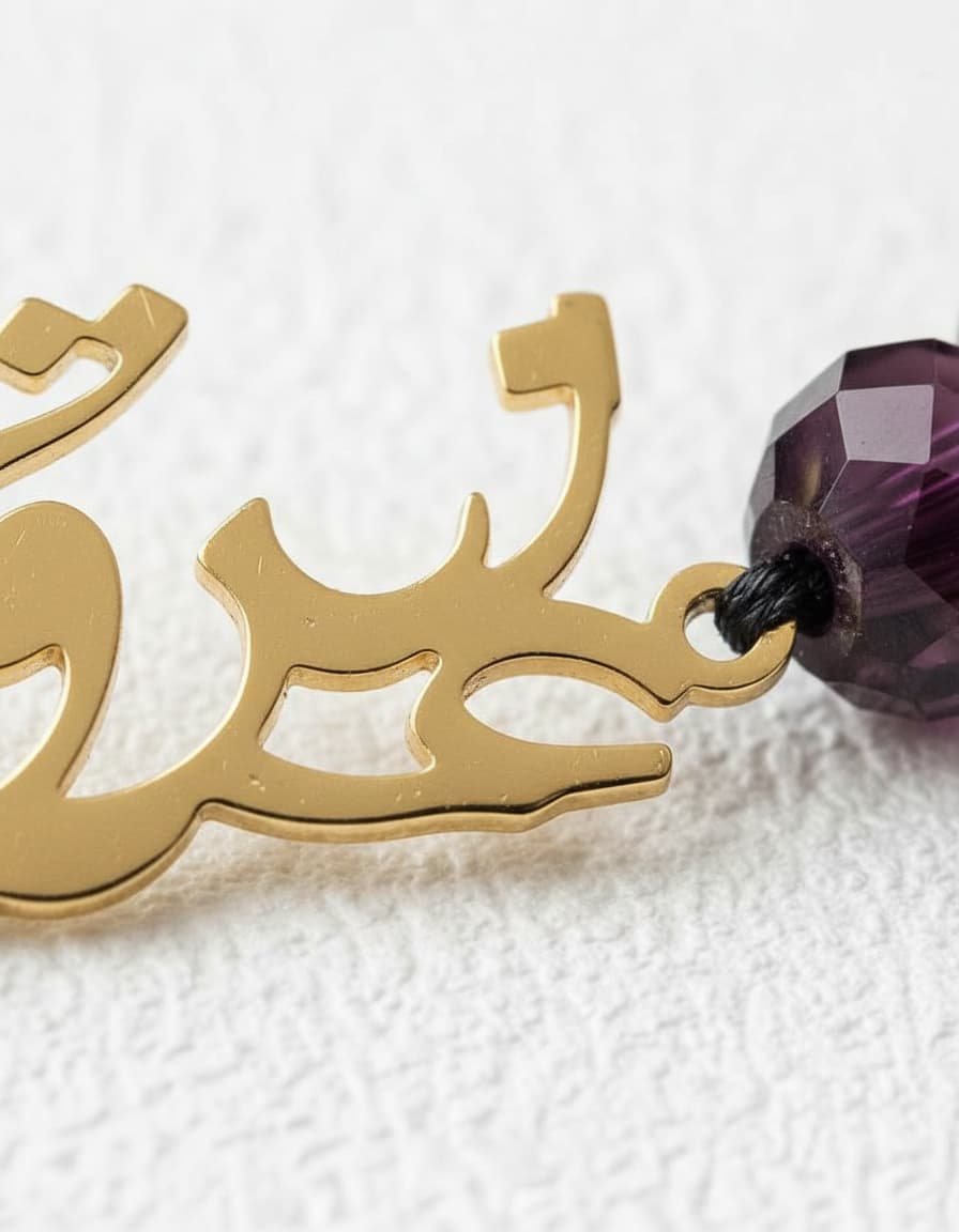 Macro close-up of the calligraphy charm and purple beads
