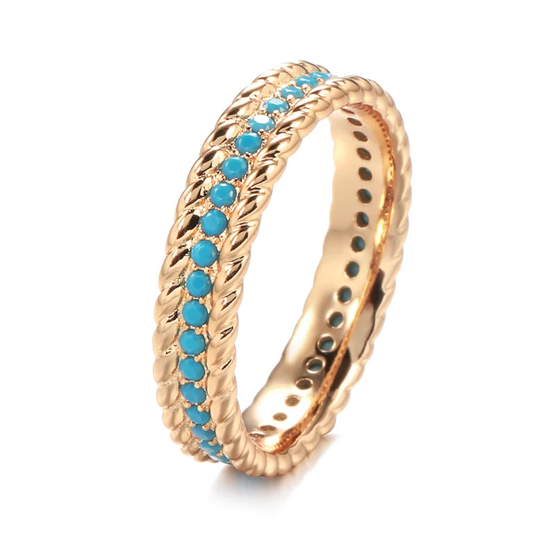 Gold ring with turquoise stones on a white background