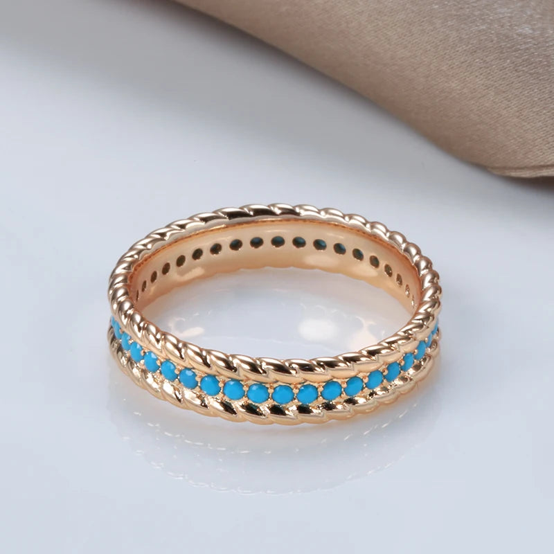 Gold ring with turquoise stones on a light background