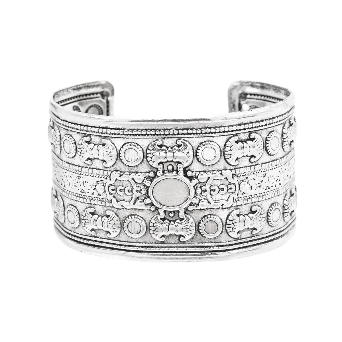 Wide silver-toned cuff bracelet with intricate carved patterns on white background