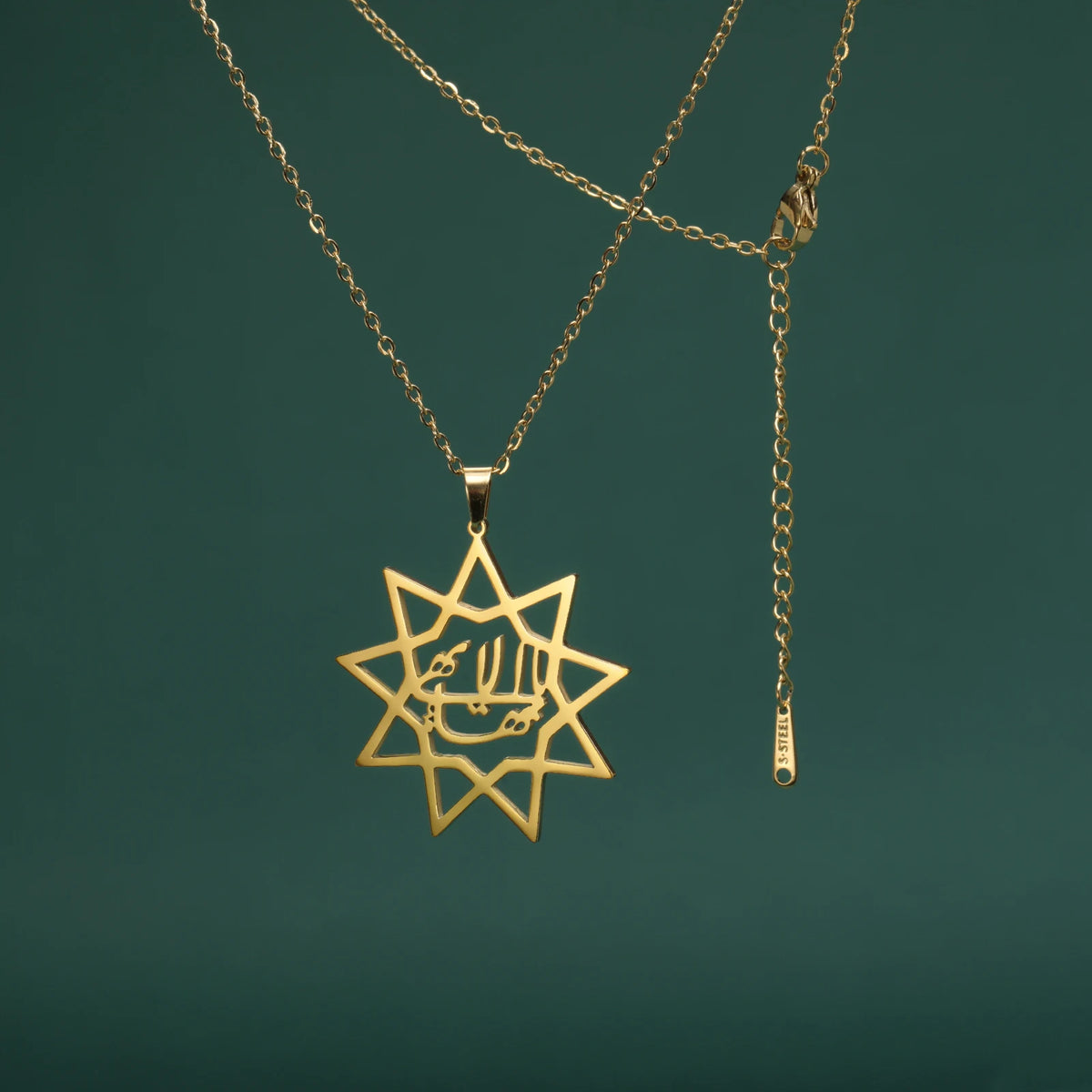 Gold star-shaped pendant on a chain against a dark green background