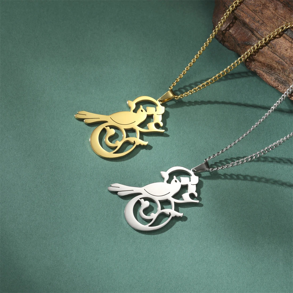 Gold and silver bird-shaped pendants on chains against a green background