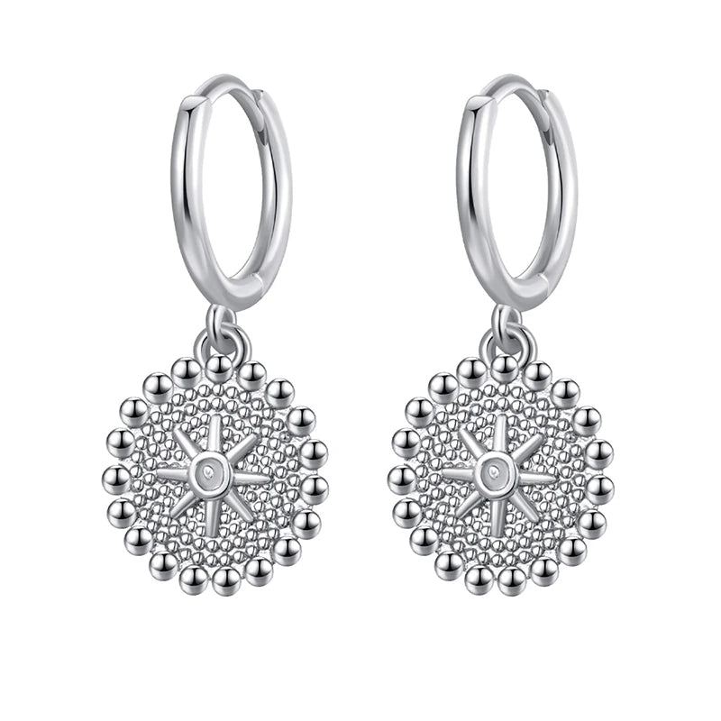 Pair of silver hoop earrings with intricate designs on a white background