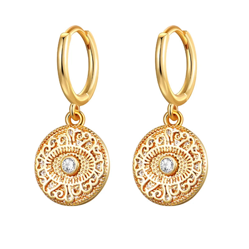 Gold hoop earrings with intricate circular designs and small diamonds on a white background