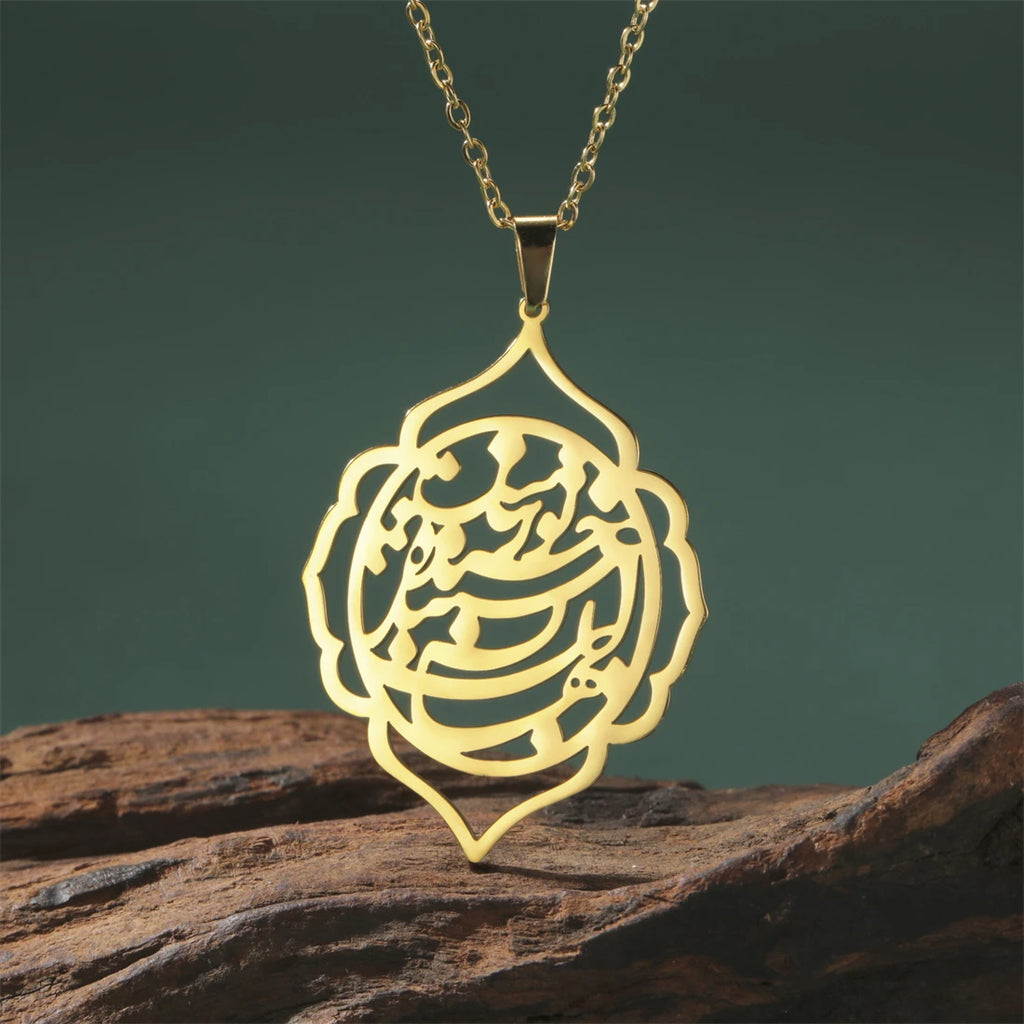 Gold necklace with a intricate pendant on a wooden surface