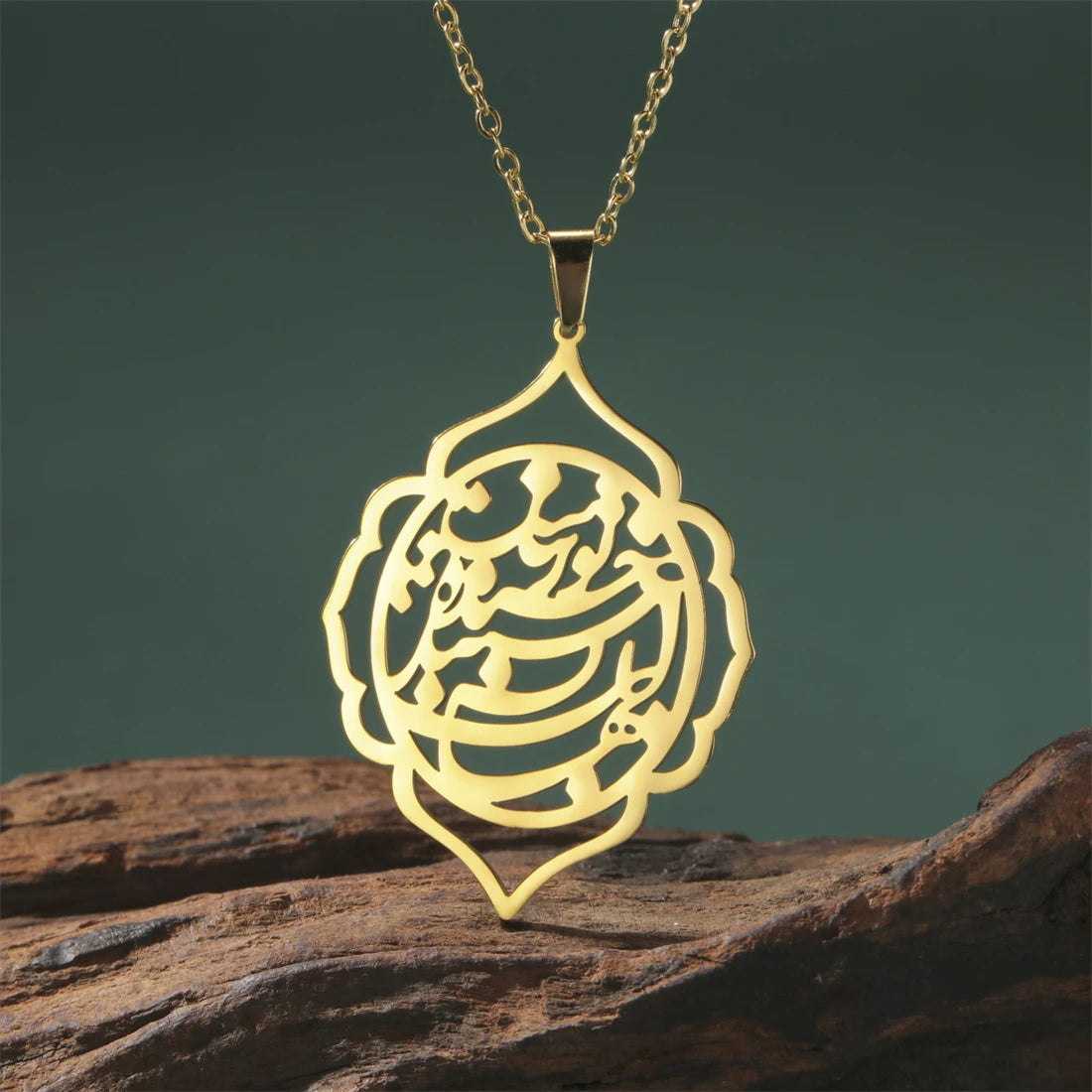 Gold necklace with a intricate pendant on a wooden surface