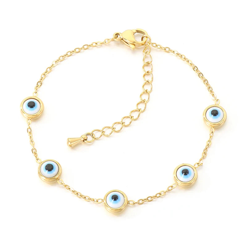 Gold evil eye beaded bracelet set with five round light blue and black evil eye charms, displayed on a clean white background.