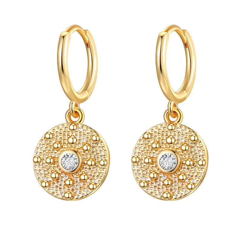Gold hoop earrings with circular pendants on a white background