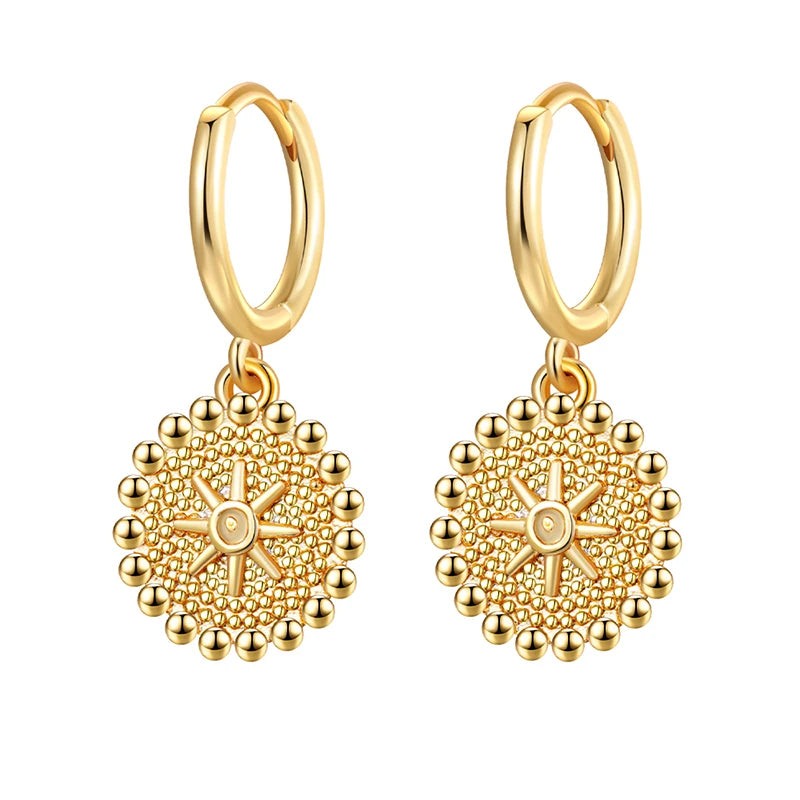 Gold hoop earrings with intricate designs on a white background