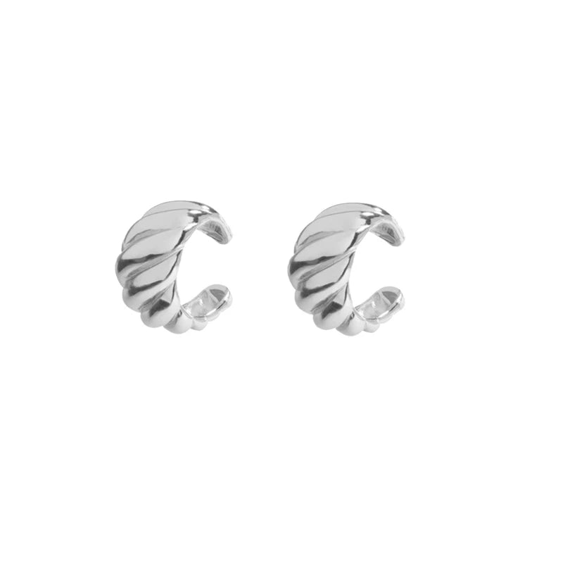 A pair of silver-toned twisted huggie hoop earrings with a textured, ribbed design, shown on a plain white background.