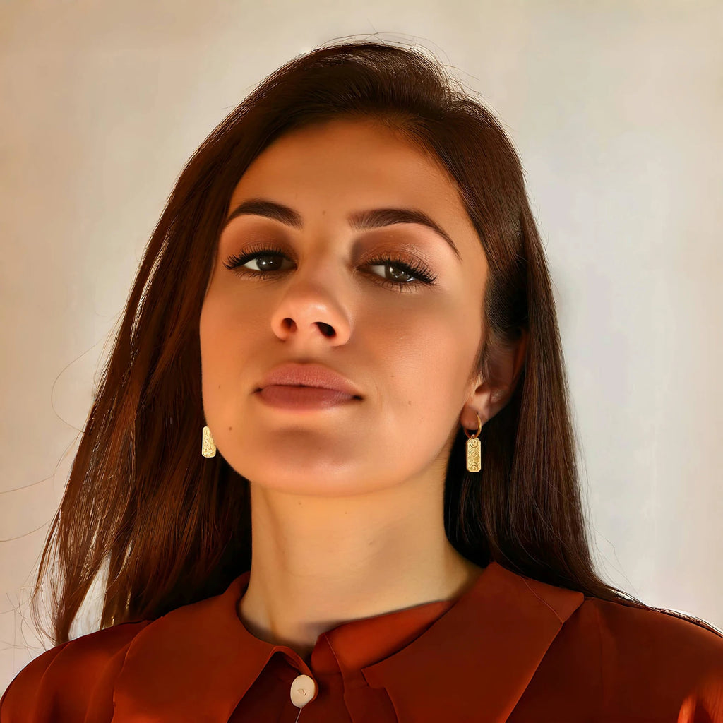 Woman wearing gold evil eye earrings