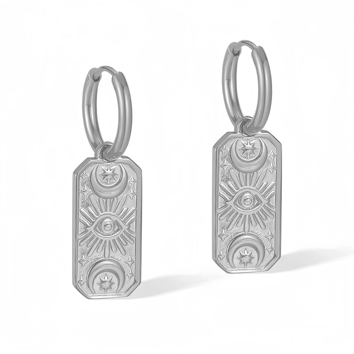 Silver evil eye hoop earrings with engraved designs on white background