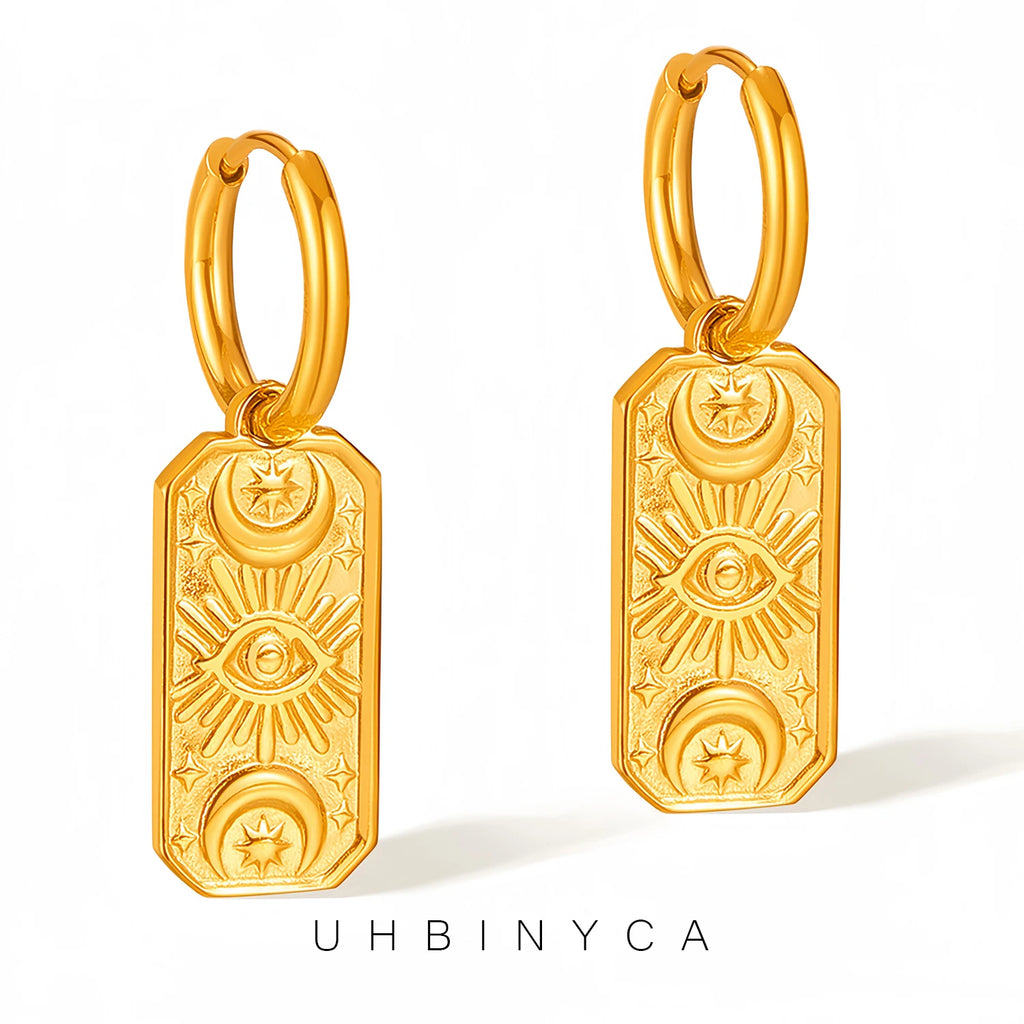 Gold hoop evil eye earrings with intricate designs on white background