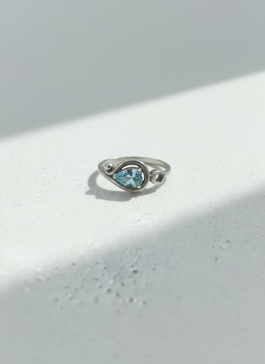 Silver sky-blue pear stone ring on white background