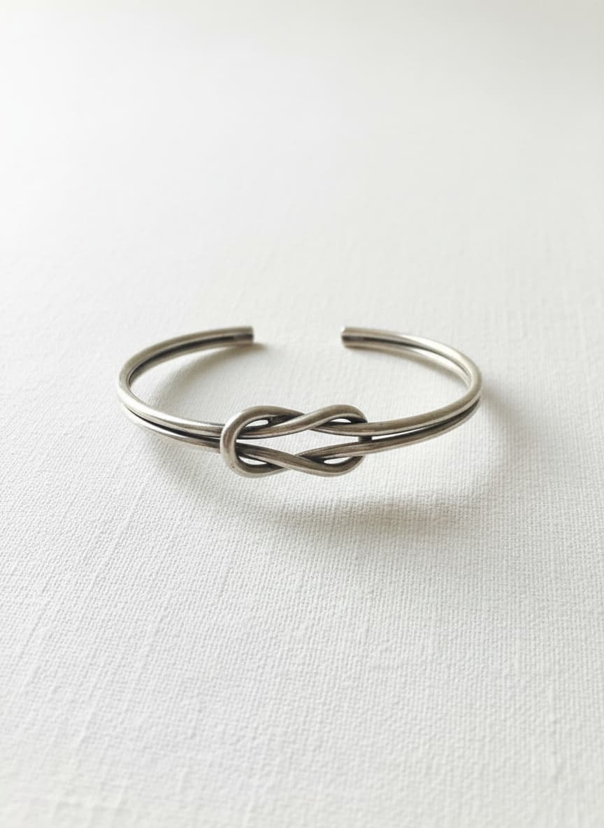 Silver-tone knot bangle on white
