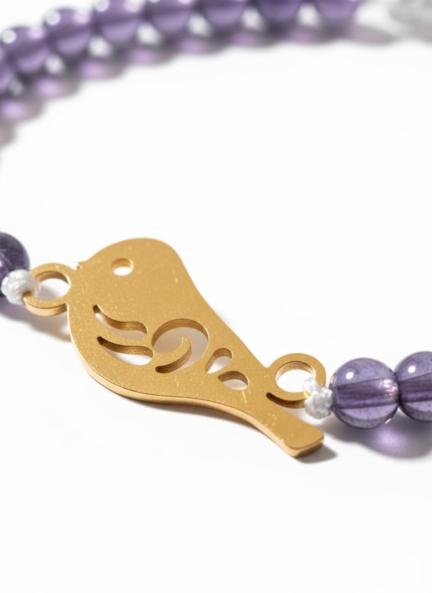 Macro close-up of the gold bird calligraphy charm