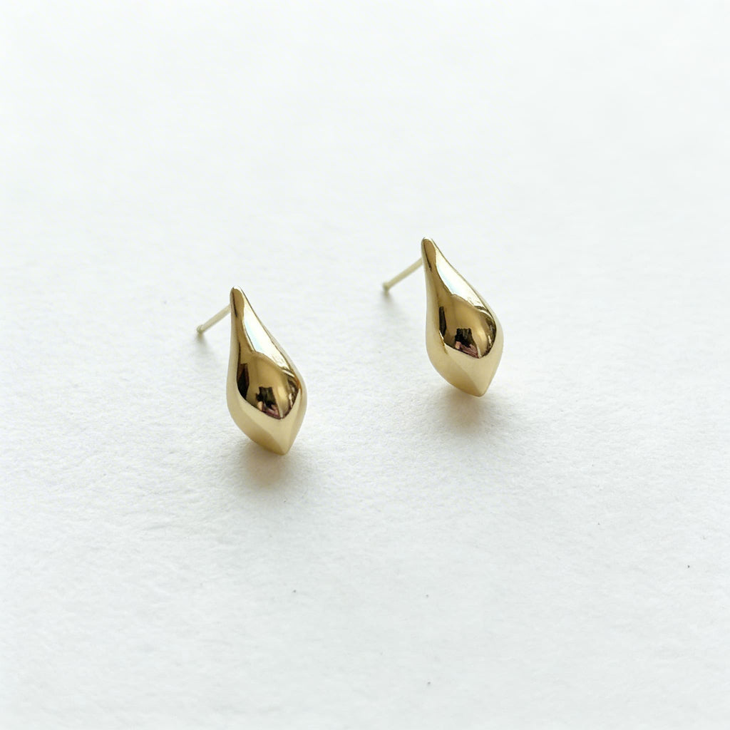 Gold teardrop hanging earrings on white