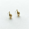 Gold teardrop hanging earrings on white