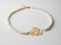Gold-plated calligraphy side necklace with pearl beads on white
