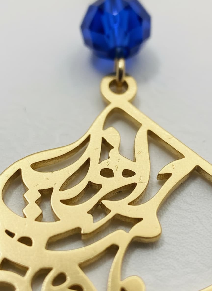 Close-up of the gold calligraphy pendant