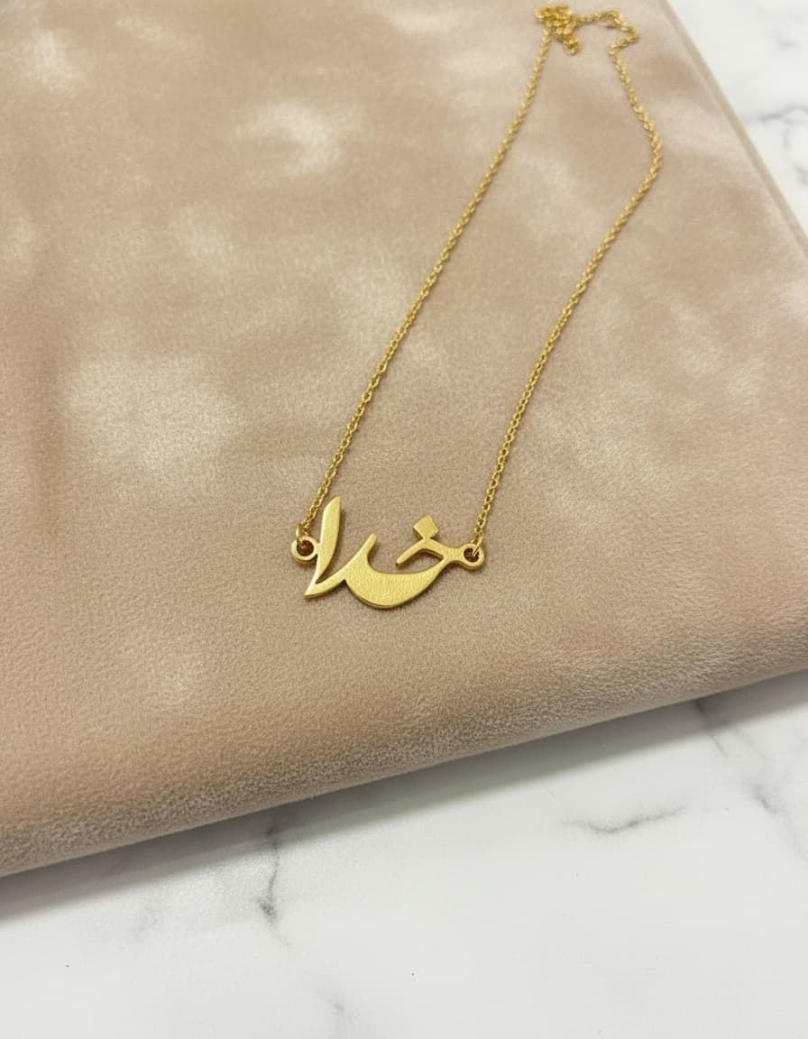 Gold-plated Persian calligraphy nameplate necklace on velvet