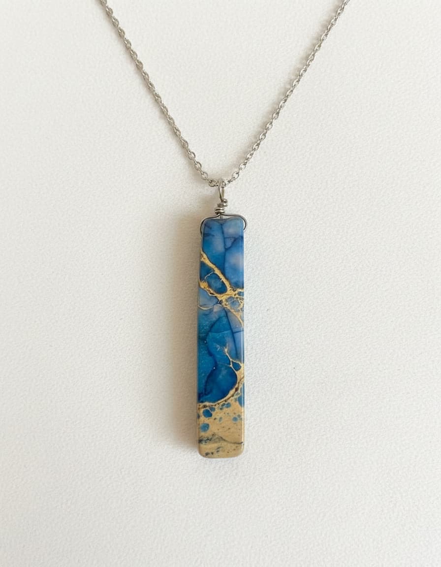Blue and gold marbled bar pendant necklace on white background