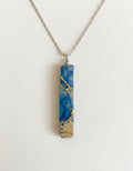 Blue and gold marbled bar pendant necklace on white background