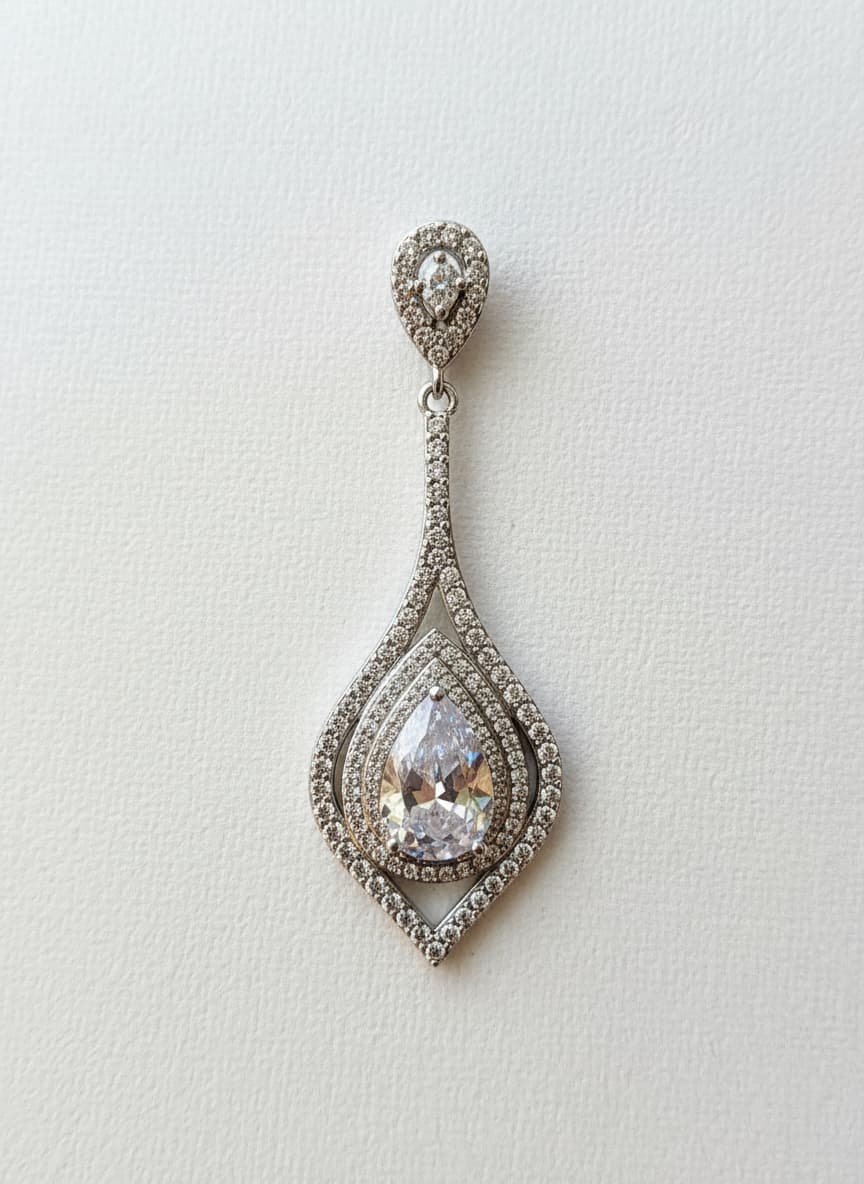 Silver-plated teardrop earrings with man-made diamonds on white
