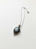 Deep banded agate cabochon pendant in ornate silver-tone filigree on a fine chain